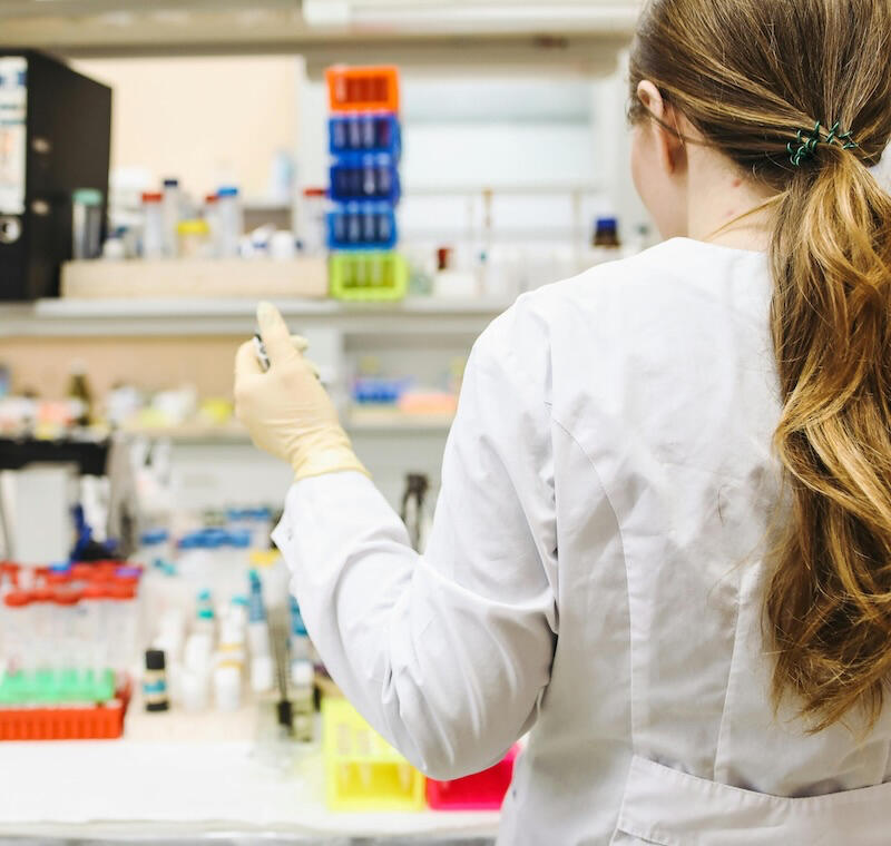 A lab worker using microinjection equipment in a laboratory setting